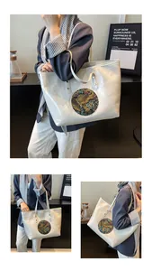 Detailed macro of white glossy tote bag featuring circular ethnic elephant embroidery