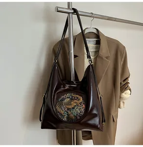 Detail of vintage embossed elephant pattern on dark brown faux leather tote bag