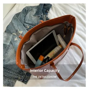 Vista detallada del interior espacioso del bolso marrón con tableta y cosméticos