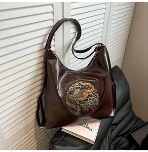 Detail of vintage brown tote bag with colorful elephant relief and shiny PU leather texture