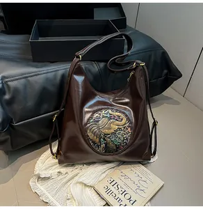 Detailed close-up of vintage dark brown hobo bag featuring elephant embossed metal plate