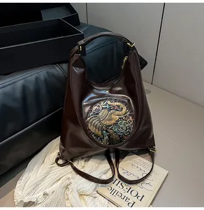 Detail of vintage coffee PU leather backpack with colorful elephant relief emblem