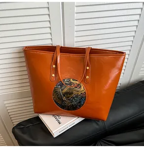 Close-up of vintage embossed elephant emblem on large brown leather tote bag detail
