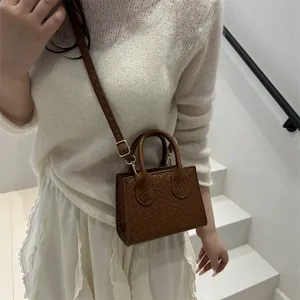 Brown faux crocodile textured small crossbody bag with gold hardware and top handle
