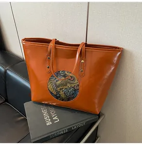 Close-up of brown faux leather tote bag featuring a colorful elephant embossed emblem