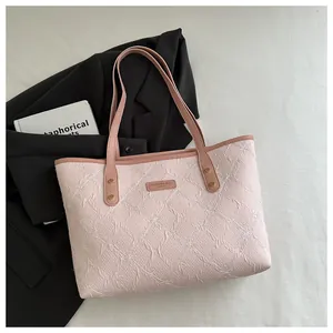 Close-up of pink quilted tote bag with floral embroidery and CAHRES & WEKA brand logo