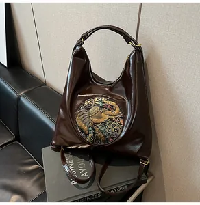 Close-up of retro brown hobo bag featuring ethnic elephant embossed pattern and leather texture