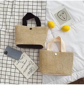 Top-down view of woven straw handbags with canvas handles and button closure details