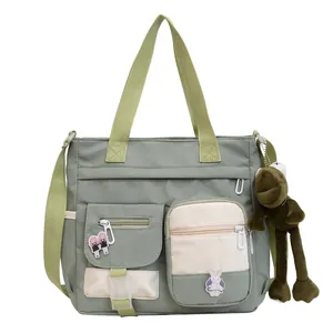 Large gray-green canvas tote bag with multiple pockets and cute plush frog pendant