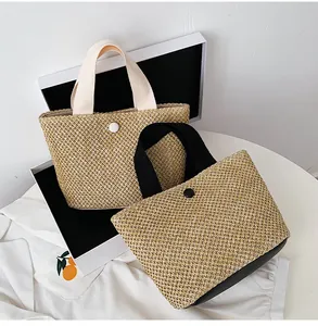 Detail of woven straw handbags featuring contrasting handles and decorative button closure