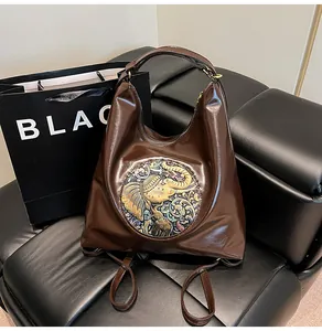 Detail of dark brown leather backpack featuring an embossed gold elephant ornament