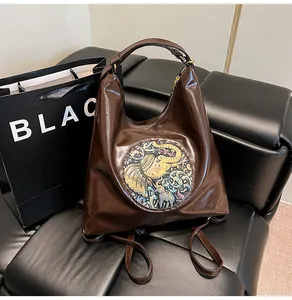 Detail view of large brown PU leather backpack with ethnic elephant relief pattern