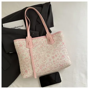 Detail of pink and beige woven tote bag featuring Hello Kitty patterns and PU handles