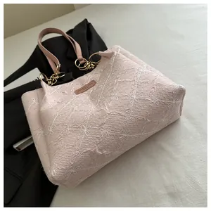 Close-up of pink wrinkled fabric tote bag with floral embroidery and leather label