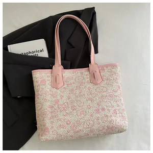 Detailed close-up of woven tote bag with pink leather trim and floral smile patterns