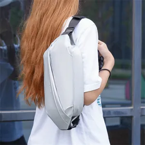 Detail of silver metallic crossbody chest bag showing adjustable strap and buckle on model