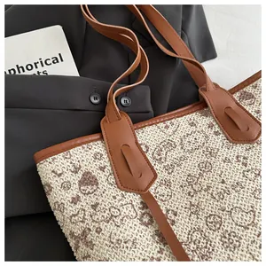 Detailed macro view of woven tote bag texture with brown leather trim and vintage patterns