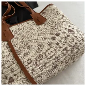 Detailed top view of a woven tote bag with brown floral patterns and leather handles