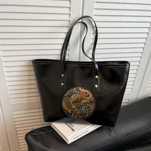 Ethnic style black leather tote bag with a metallic embossed elephant pattern on front
