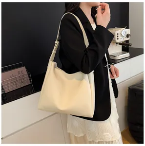 Chic cream oversized hobo tote bag with wide shoulder strap shown in a modern interior setting