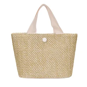 Minimalist straw woven tote bag with canvas handles and snap button for summer beach vacations