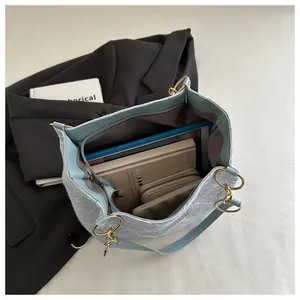Close-up of floral lace shoulder bag showing spacious interior with tablet and books