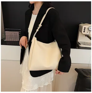 Close-up of cream leather tote bag with natural texture shown on fashion model
