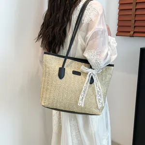 Sac cabas en paille contrastée avec nœud en dentelle blanche et lanières en cuir noir pour l'été