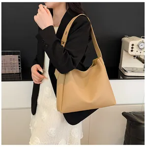 Close-up of minimalist apricot tote bag showing premium leather texture and wide strap
