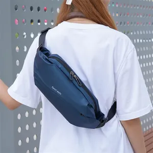 Navy blue crossbody sport sling bag with adjustable strap shown on a model outdoors