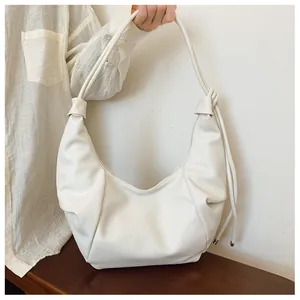 Detail of white hobo bag with soft leather texture and stylish pleated design