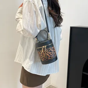 Detail of leopard print bucket bag with gold zippers and stylish crossbody strap