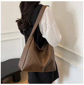 Detail view of large dark brown tote bag showing its soft leather texture and capacity