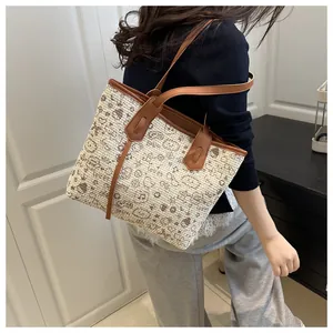 Detailed side view of woven tote bag featuring cartoon patterns and brown leather straps