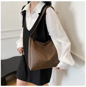 Detailed side view of a large brown leather tote bag on model for daily styling