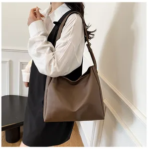 Detail view of large dark brown leather tote bag with adjustable shoulder strap for women