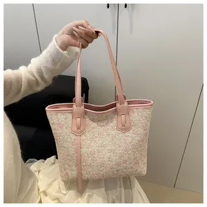 Detail view of woven daisy pattern and pink leather handle on a large tote bag
