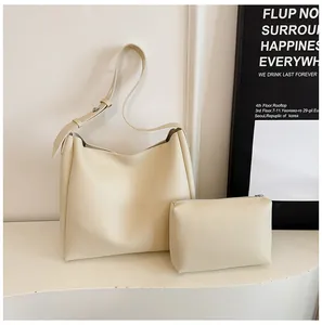 Close-up of minimalist beige tote and pouch set with fine texture and wide shoulder strap