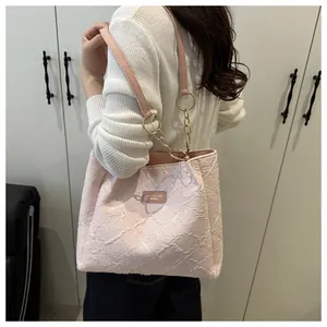 Detail of pink embroidered tote bag with floral patterns and gold chain strap