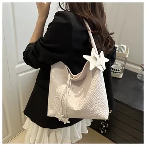 Détail d'un sac à bandoulière tressé crème de grande capacité avec pendentif étoile