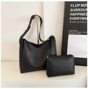 Detail of minimalist black tote bag set featuring large shoulder bag and small zipper pouch