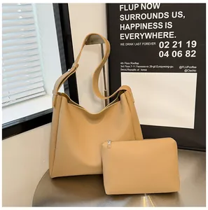 Beige tote bag set with small pouch on a metal table in a modern interior setting