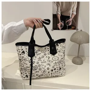 Detail of canvas tote bag featuring creative black hand-drawn graffiti art on off-white fabric