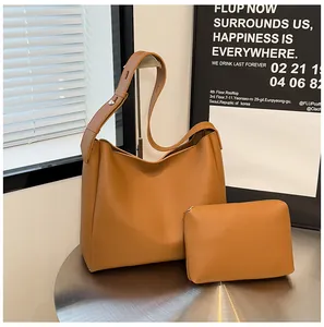 Detail view of caramel brown tote bag set with wide adjustable strap and silver metal rivets
