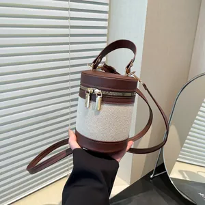 Detail of contrast stitch bucket bag with brown leather and cream canvas texture