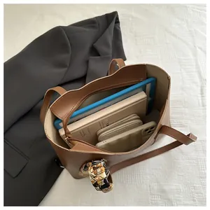 Interior view of brown tote bag showing large capacity with tablet and notepad inside