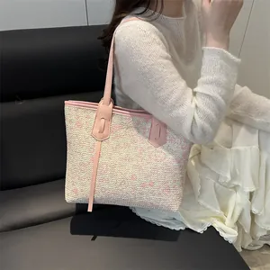 Floral knit tote bag with pink leather handles shown by model in a minimal interior