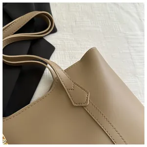 Detail of premium khaki PU leather tote bag showing fine stitching and strap attachment