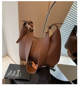 Macro detail of brown coffee hobo bag showing matte leather texture and metal buckle