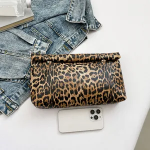 Comparaison de taille détaillée d'une pochette léopard à côté d'un smartphone blanc